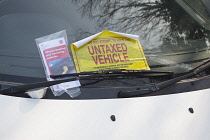 Transport, Road, Cars, Ticket placed on windscreen of clamped untaxed vehicle.