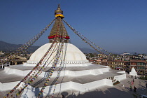 Nepal, Kathmandu, The Great Stupa surrounded by the buildings of Bodhnath, with Himalayan foothills in the distance.