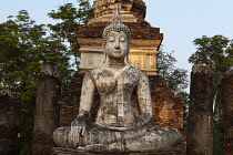 Thailand, Sukothai, Cracked, seated, white Buddha in front of brick stupa, Wat Trapang Ngoen.
