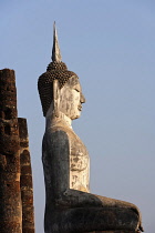 Thailand, Sukothai, Seated, white Buddha, lit by setting sun, Wat Mahathat Royal Temple.