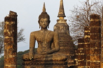 Thailand, Sukothai, Seated Buddha, with gold-painted fingernails, in the warm glow of sunset, Wat Mahathat Royal Temple.