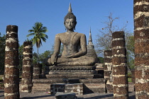 Thailand, Sukothai, Row of pillars leading up to a seated Buddha on a plinth, Wat Mahathat Royal Temple.