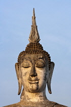 Thailand, Sukothai, Head of a seated Buddha in the warm glow of sunset, Wat Mahathat Royal Temple.