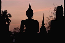 Thailand, Sukothai, Head of a seated Buddha silhouetted at sunset, Wat Mahathat Royal Temple.