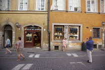 Poland, Warsaw, Old Town, Swietojanska, Tourist having picture take outside Amber gift shop.