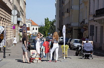 Poland, Warsaw, Nowy Swiat, Younmg firls selling clothes on the street.