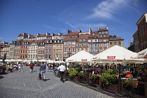 Poland, Warsaw, Old Town Square, rynek Starego Miasta, Tourists sat at outdoor restaurant seating area.