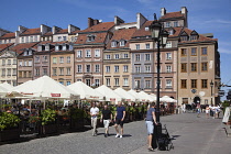Poland, Warsaw, Old Town Square, rynek Starego Miasta, Tourists sat at outdoor restaurant seating area.