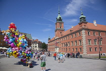 Poland, Warsaw, Old Town, Plac Zamkowy, Arkady Kubickiego, Red Brick Royal Castle with balloon vendor in the foreground.