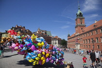 Poland, Warsaw, Old Town, Plac Zamkowy, Arkady Kubickiego, Red Brick Royal Castle with balloon vendor in the foreground.