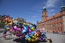 Poland, Warsaw, Old Town, Plac Zamkowy, Arkady Kubickiego, Red Brick Royal Castle with balloon vendor in the foreground.