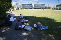 Poland, Warsaw, Plac Marszalka Jozefa, modern Metropolitan building with scholl kids sketching in the foreground.