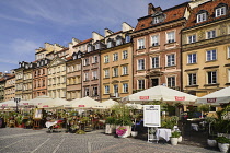 Poland, Warsaw, Stare Miasto or Old Town Square, Colourful facades of buildings on the north side of the square with open air restaurant in the foreground.