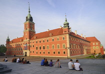Poland, Warsaw, Royal Castle in Plac Zamkowy or Castle Square with people enjoying the evening sun.
