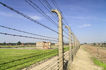 Poland, Auschwitz-Birkenau State Museum, Birkenau Concentration Camp, Ruins of former accommodation blocks surrounded by barbed wire fencing.