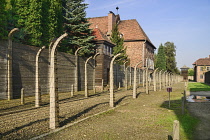 Poland, Auschwitz-Birkenau State Museum, Auschwicz Concentration Camp, Perimeter barbed wire fencing and guard tower beside Block 11 known as 'The Death Block'.