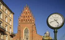 Poland, Krakow, Dominican Church of the Holy Trinity with street clock in the foreground.