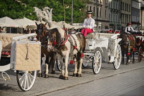 Poland, Krakow, Rynek Glowny or Main Market Square, horse drawn tourist carriages awaiting customers.