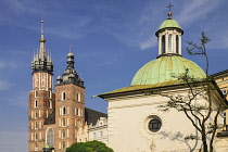 Poland, Krakow, Rynek Glowny or Main Market Square, St Mary's Church also known as St Marys Basilica with the domed Church of St Adalbert to the right.