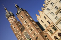 Poland, Krakow, Rynek Glowny or Main Market Square, St Mary's Church also known as St Marys Basilica, angular view with nearby buildings.