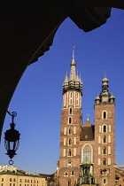 Poland, Krakow, Rynek Glowny or Main Market Square, St Mary's Church also known as St Marys Basilica, view through an arch of the Cloth Hall.