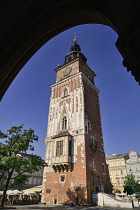 Poland, Krakow, Rynek Glowny or Main Market Square, Wieza Ratuszowa or Town Hall Tower framed with an arch of the Sukiennice or The Cloth Hall.