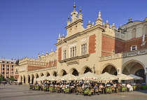 Poland, Krakow, Rynek Glowny or Main Market Square, Evening dining on the west side of the square with Sukiennice or The Cloth Hall.