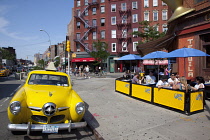 USA, New York State, New York City, Manhattan, Greenwich village, Yellow Studebaker car parked outside the Caliente Cab Co Bar on the corner of Bleecker Street and 7th Avenue.