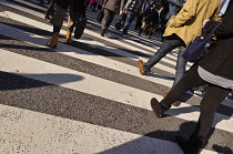 Japan, Tokyo, Shibuya, Shoppers walk across  the street in Zebra crossing crosswalk in front of Shibuya station.