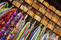 Japan, Kyoto, Fushimi Inari Taisha shrine, wooden plaques called ema with requests from worshippers, strings of origami paper cranes as offerings.