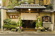 Japan, Kyoto, Traditional restaurant near Nishiki Market, entrance traditional New Year's front door decorations bamboo, pine boughs, flowers.