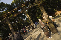 Japan, Tokyo, Harajuku, Two young men in traditional Japanese men's kimono in front of the huge Torii infront of Meiji - jingu shrine during New Year's celebrations.