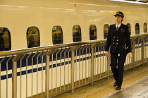 Japan, Tokyo, JR Tokyo station, on the train platform, a woman train driver about thirty years old, in JR uniform, walking to board shinkansen train.