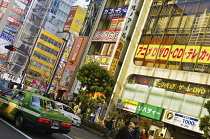 Japan, Tokyo, Akihabara, Busy street scene with taxi in foreground.