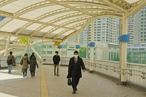 Japan, Tokyo, Tamachi JR Train station, the end of the large bridge passing over the train tracks, people walking.