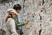 Turkey, Tourists placing messages on wall, House of the Virgin Mary, Meryemana, near Ephesus and Selcuk.