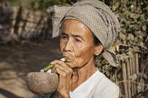 Myanmar, Bagan, Old woman smoking a cheroot, Minnanthu.