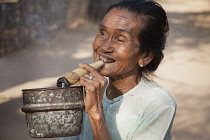 Myanmar, Bagan, Old woman smoking a cheroot, Minnanthu.