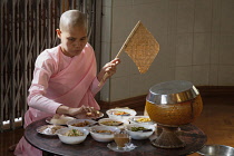 Myanmar, Mandalay, Nun at mealtime, Sakyadhita Thilashin Nunnery School, Sagaing.