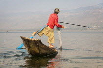 Myanmar, Shan State, Nyaung Shwe, Intha fisherman fishing in a traditional fishing boat, Inle Lake.