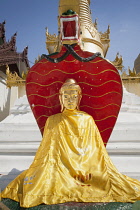 Myanmar, Yangon, A colourful Buddha statue at Shwedagon Pagoda.