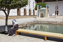 Uzbekistan, Bukhara, Lady praying, Bakhauddin Naqshband Complex, also known as Memorial of Baha Ad Din Naqshbandi.