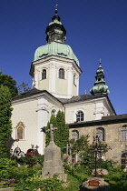 Austria, Salzburg, Stiftskirche St Peter with Petersfriedhof or St. Peter's Cemetery in the foreground.