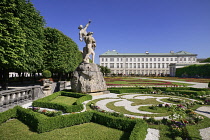 Austria, Salzburg, Mirabell Palace and Gardens with statue and flowerbeds in the foreground.