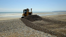 Erosion, Excavator moving shingle into banks to prevent beach erosion.