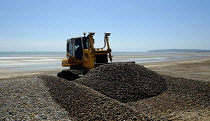 Erosion, Excavator moving shingle into banks to prevent beach erosion.