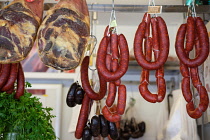 Spain, Andalucia, Cadiz, Display of jamon and chorizo at a carniceria in the Central Market.