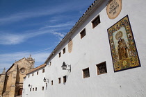 Spain, Andalucia, Cordoba, Tiled image of the Virgin of Carmen on Plaza del Conde de Priego with Iglesia de Santa Maria in the background.