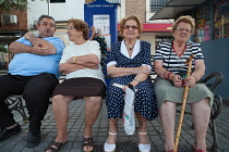 Spain, Andalucia, Cordoba, Elderly residents enjoy the evening air on a bench in a city Plaza.