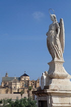 Spain, Andalucia, Cordoba, Statue of San Rafael patron saint of Cordoba on the Roman Bridge with the Mezquita Cathedral in the background.